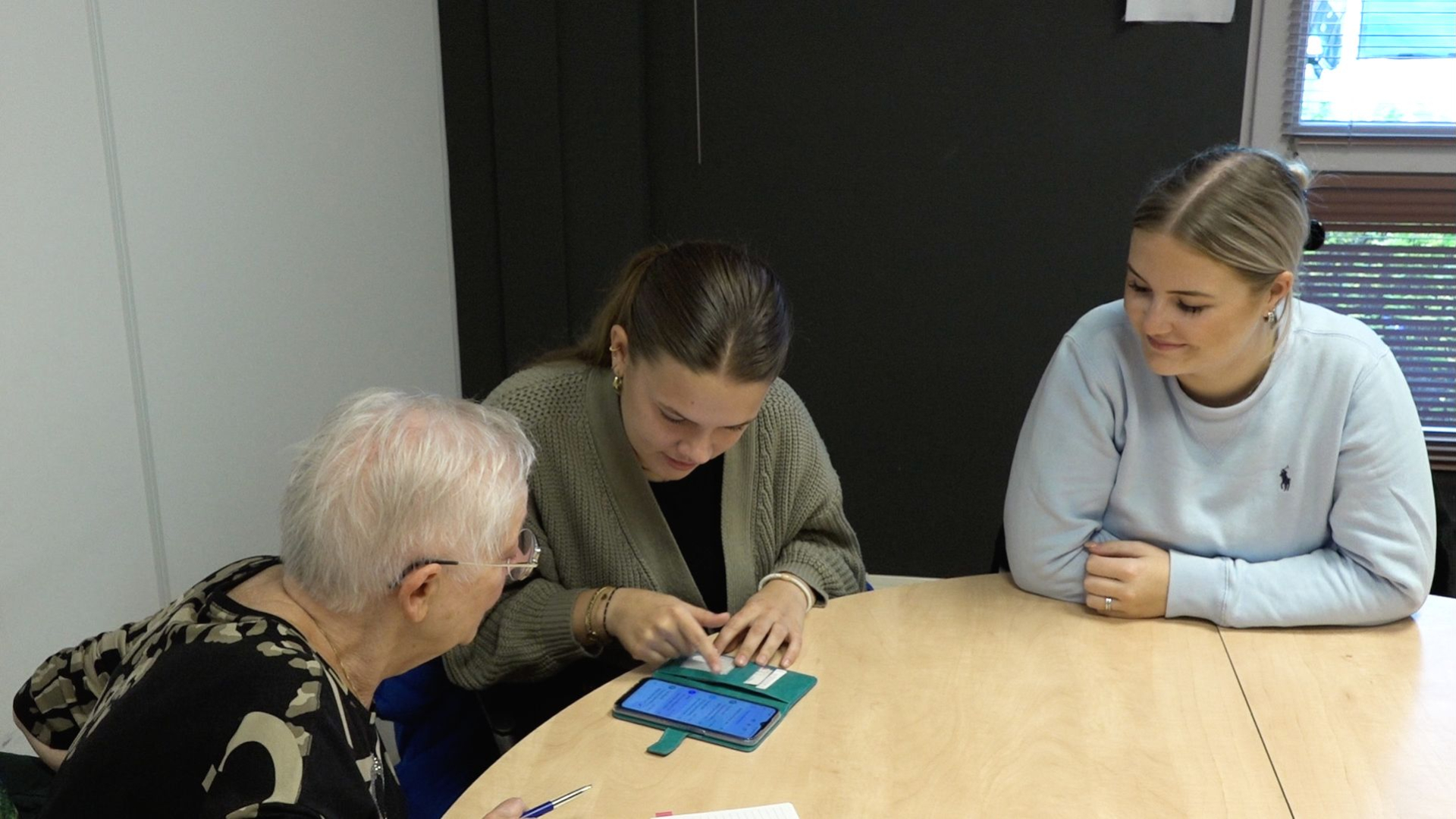 Robin, Meike en Demi geven ouderen uitleg over hun smartphone